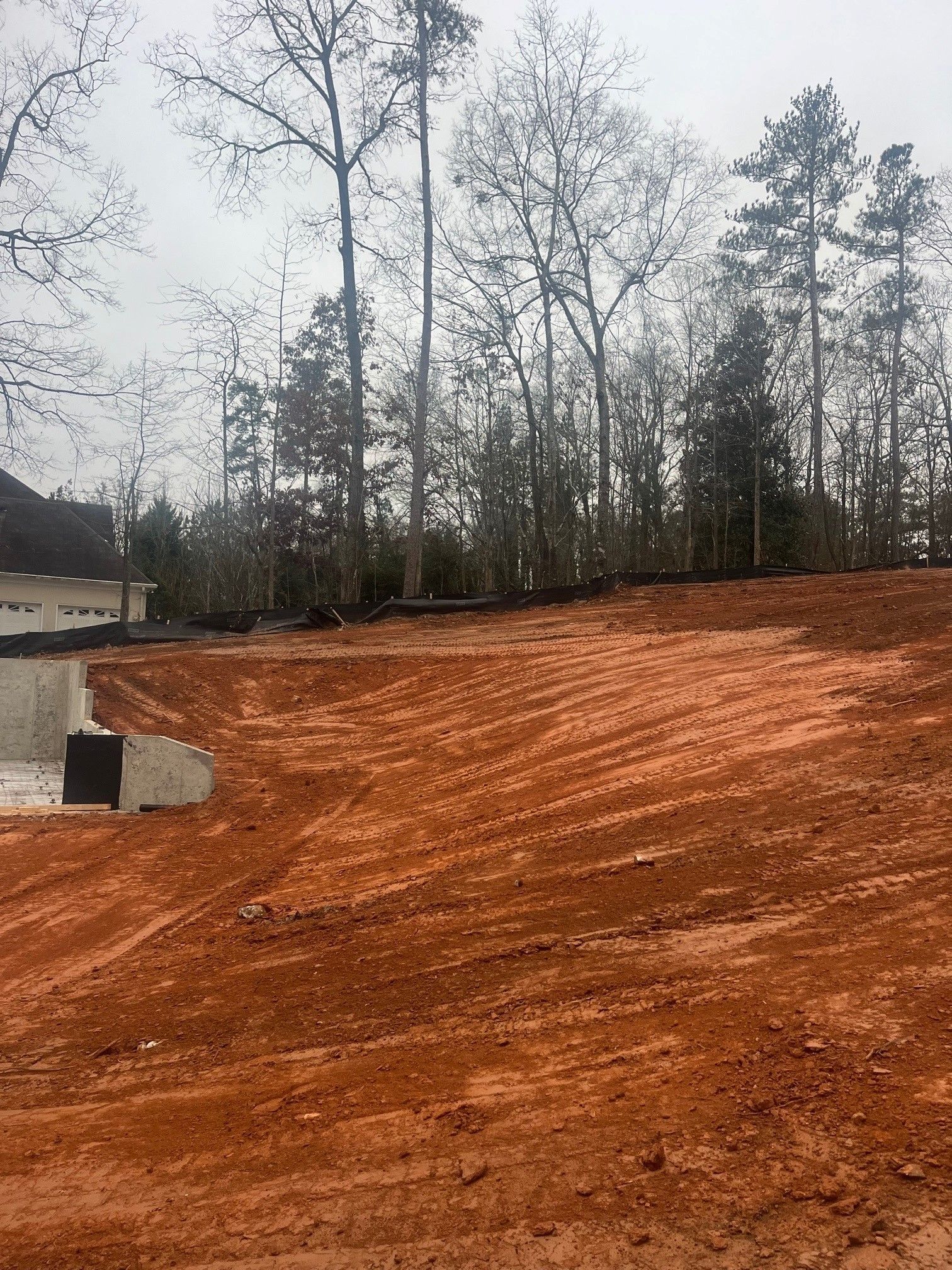 A large dirt field with trees in the background.