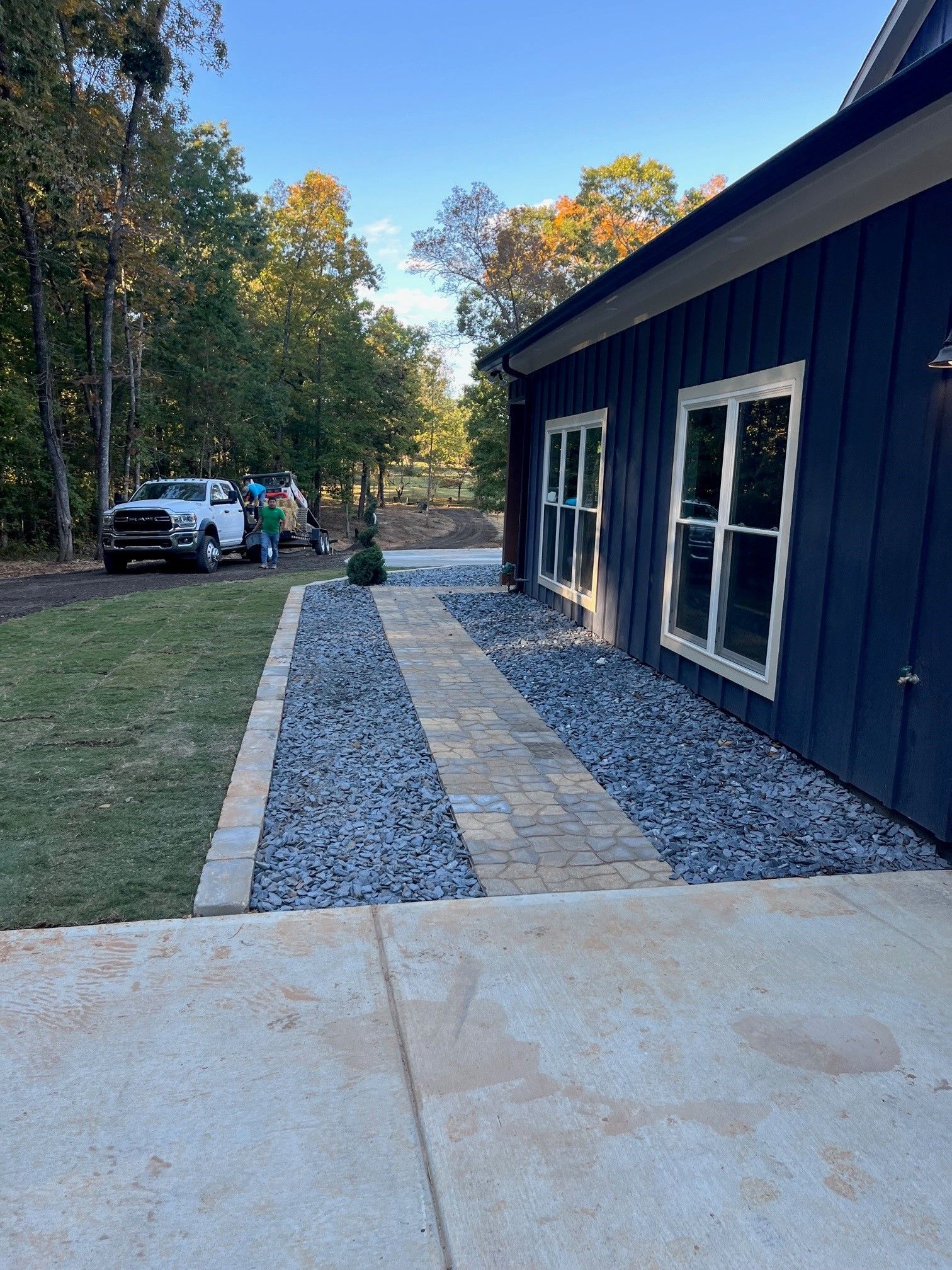 A house with a walkway leading to it and a truck parked in front of it.