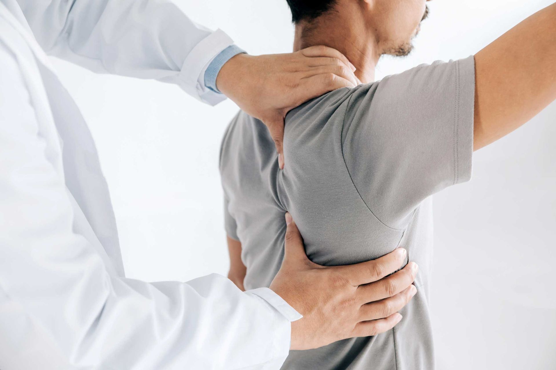 A physiotherapist is doing healing treatment on a man's back.
