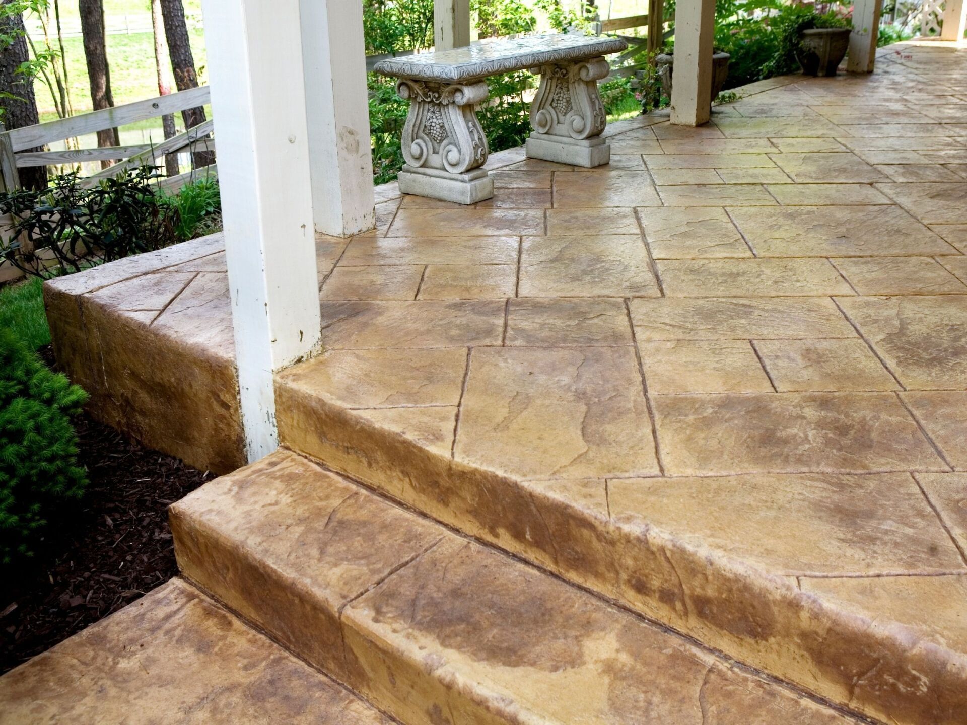 repaired concrete patio with stone bench and pillars