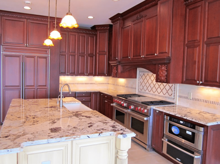 Luxury kitchen with dark wood cabinets, granite island, pendant lights, and stainless steel appliances