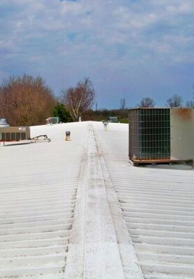 Snow-covered rooftop with HVAC units under a cloudy sky