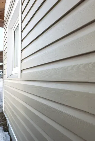 White vinyl siding on a house exterior with a window along the left side.
