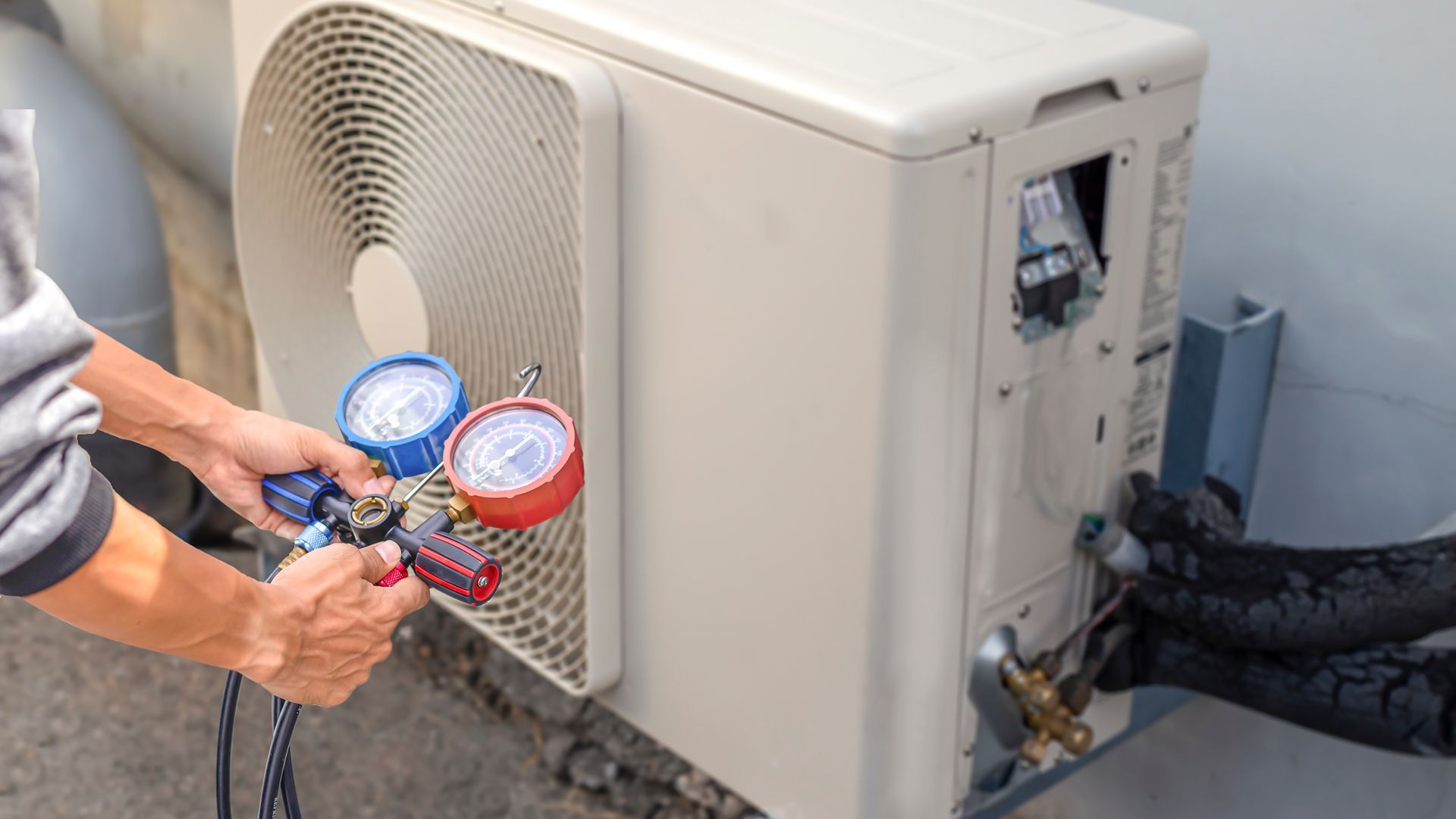 Professional HVAC repair contractor checking air conditioning system for proper performance.