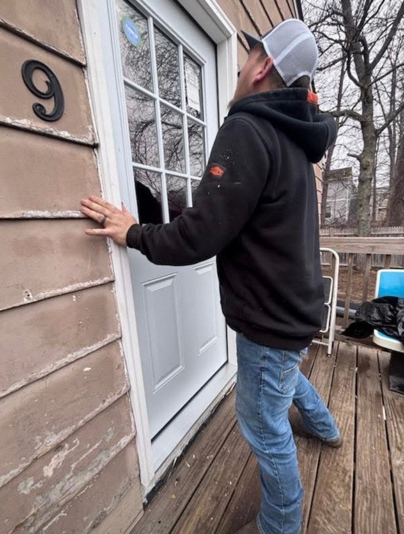 A man is standing in front of a door with the number 9 on it.