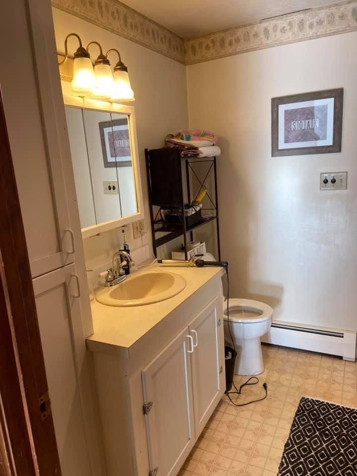 A bathroom with a sink , toilet and mirror.