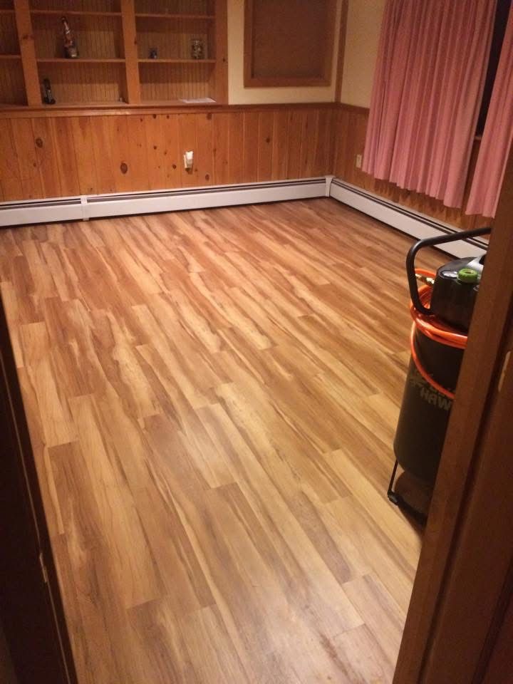 A room with a wooden floor and a vacuum cleaner in it.