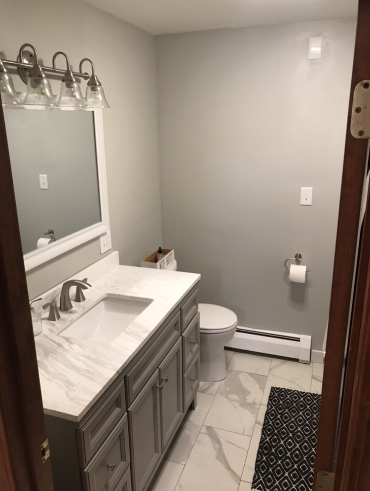 A bathroom with a sink , toilet and mirror.
