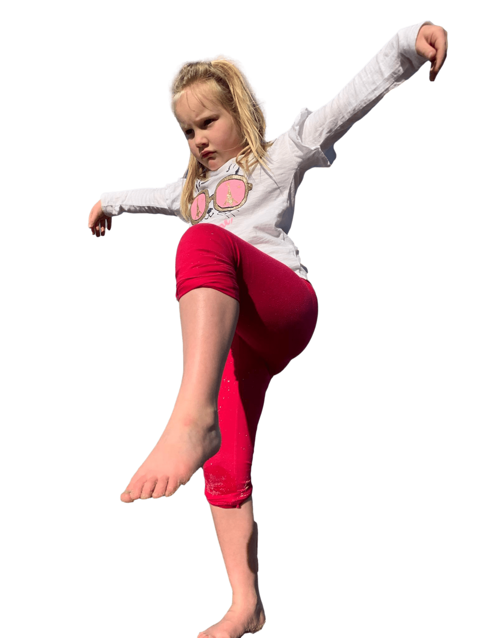 a little girl is standing on one leg on a white background .