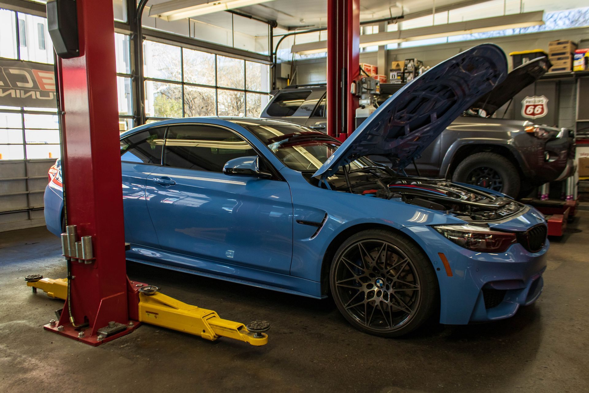 Blue BMW On Hydraulic Lift In Auto Shop Garage | Reeder's Auto & Tire Blog