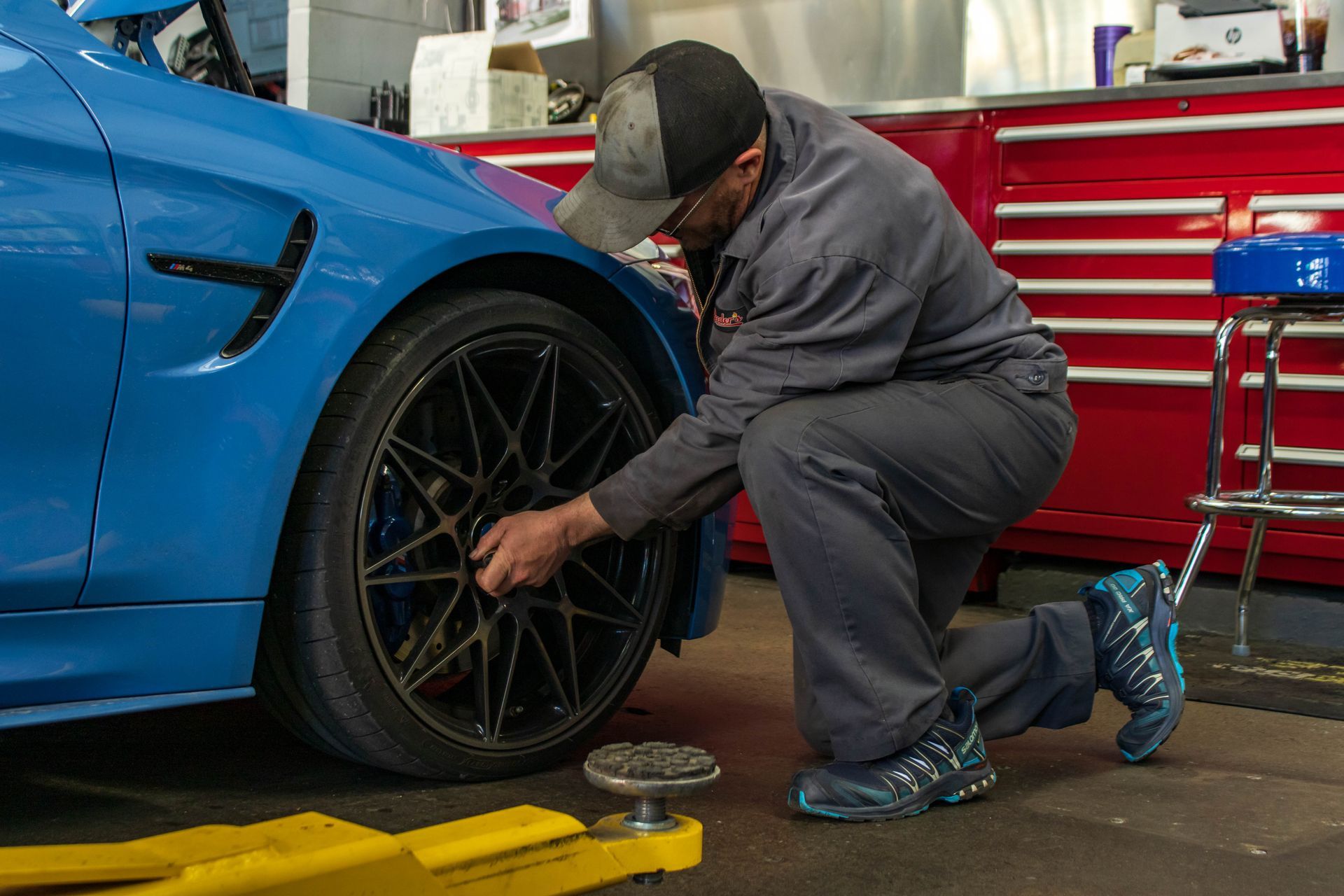 Mechanic Adjusting Blue BMW Wheel During Repair | Reeder's Auto & Tire Blog