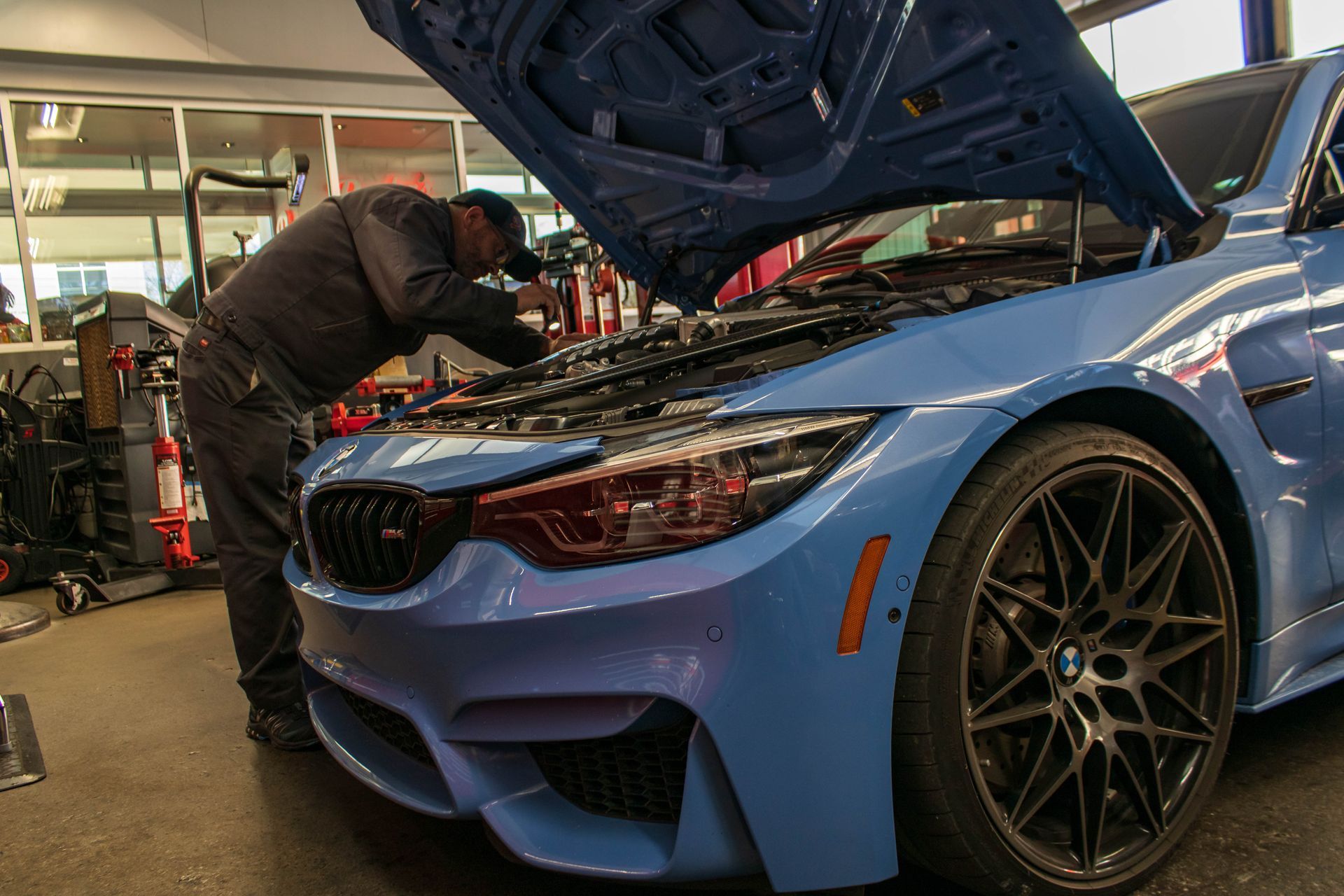 Technician Inspecting Blue BMW During Service | Reeder's Auto & Tire Blog