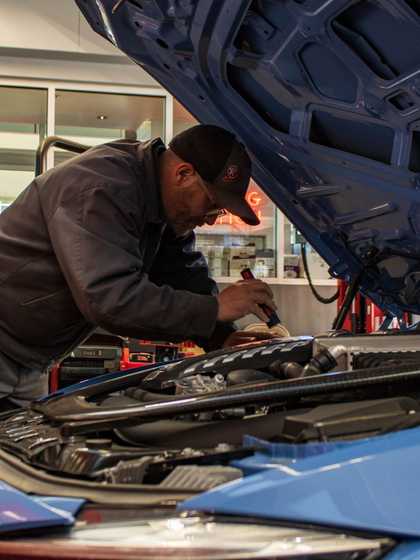 Mechanic Performing Engine Repair Under Open Hood | Reeder's Auto & Tire Blog