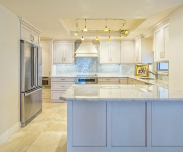 A kitchen with white cabinets and stainless steel appliances