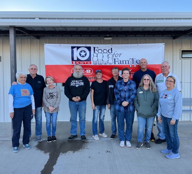 A group of people standing in front of a sign that says 10 years