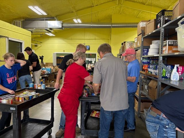 Two men are standing in a room with an exit sign above them