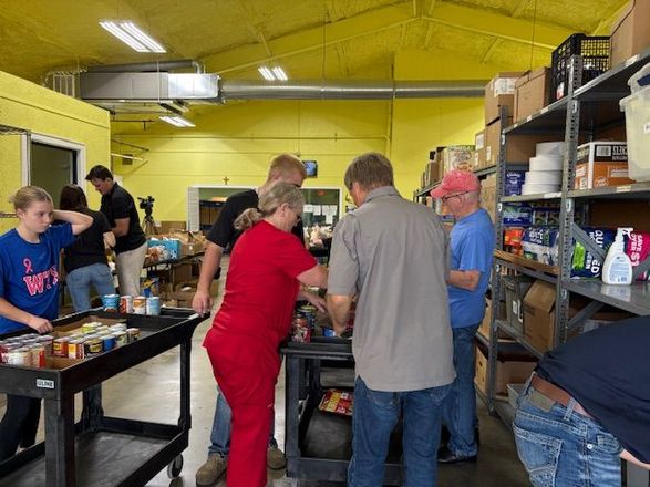 Two men are standing in a room with an exit sign above them