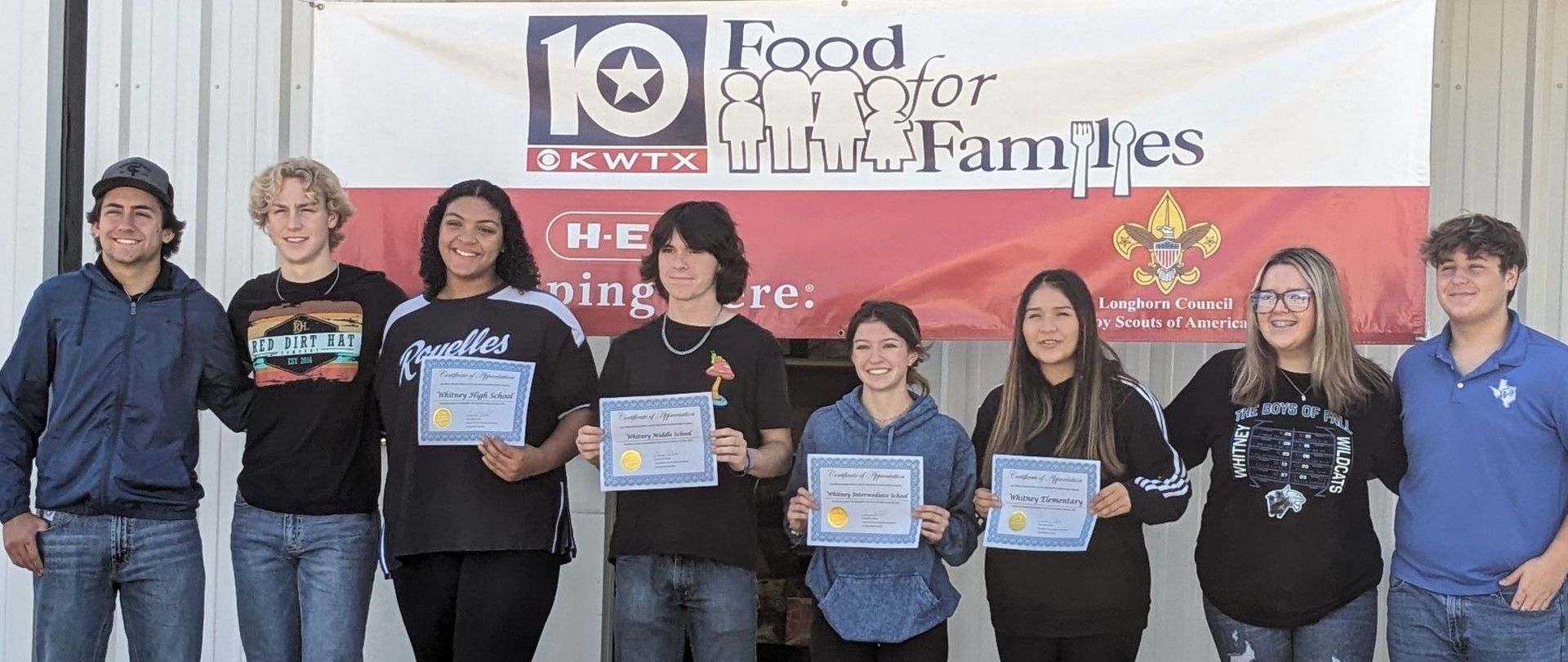 A group of young people standing next to each other holding certificates.