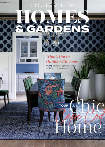 The cover of Louisville Homes & Gardens magazine featuring a dining room with blue patterned wallpaper and a chic table.