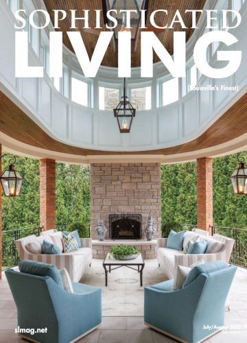 A magazine cover showing an elegant covered patio with a stone fireplace, blue armchairs, and matching white sofas.