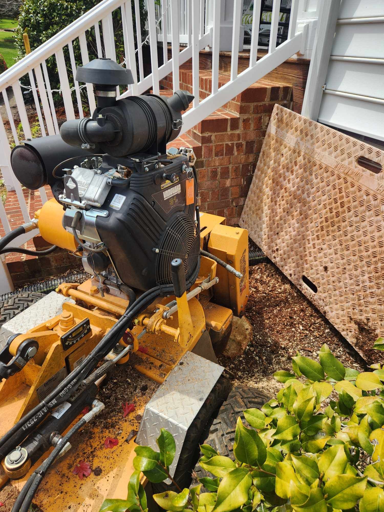 A machine is sitting on the side of a house next to a staircase.