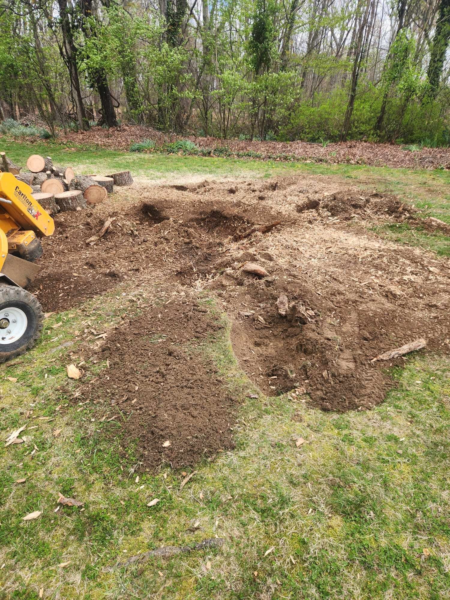 A stump grinder is working on a tree stump in a yard.