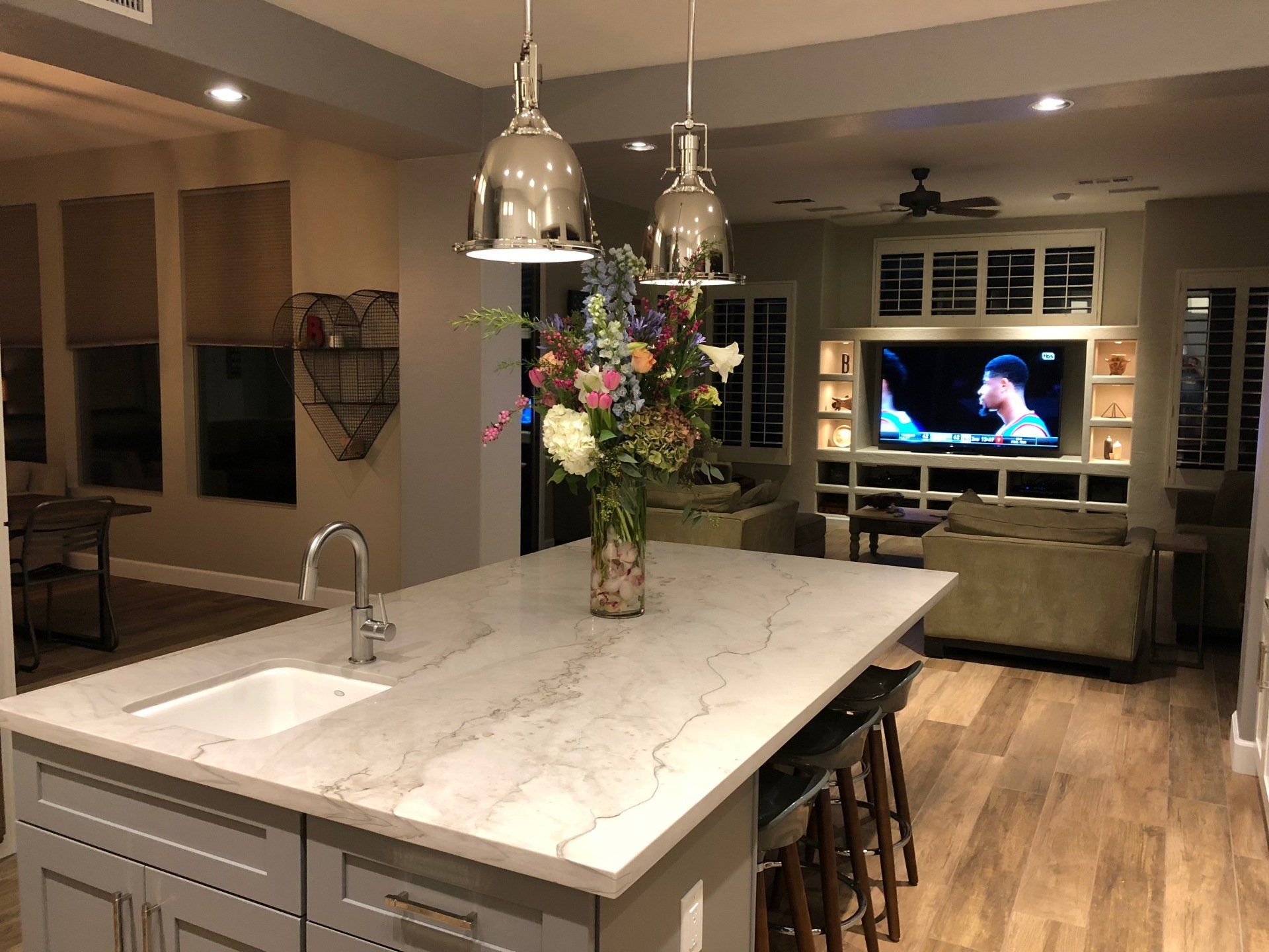 A kitchen with a large island and a vase of flowers on the counter.