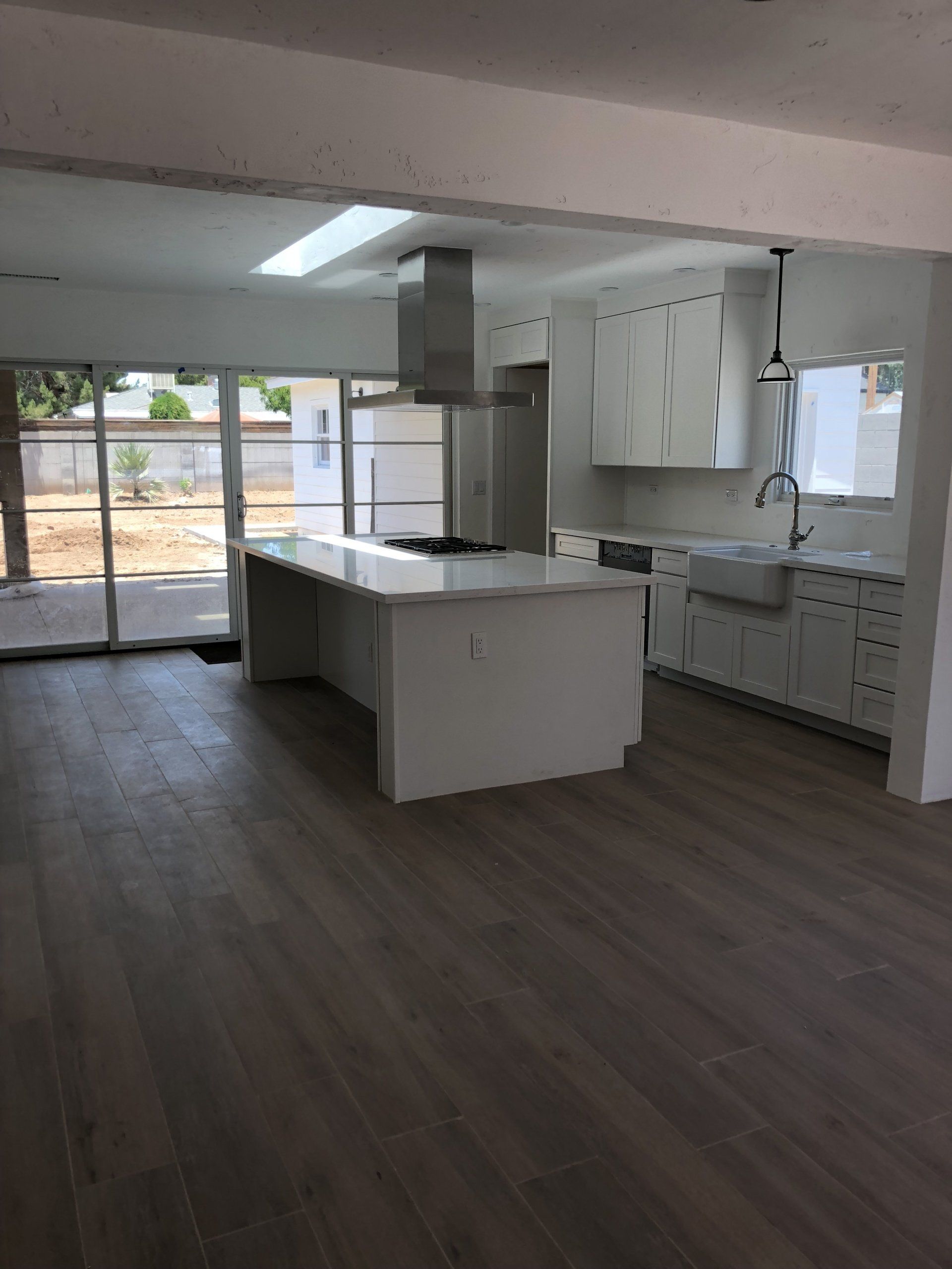 An empty kitchen with white cabinets and a large island
