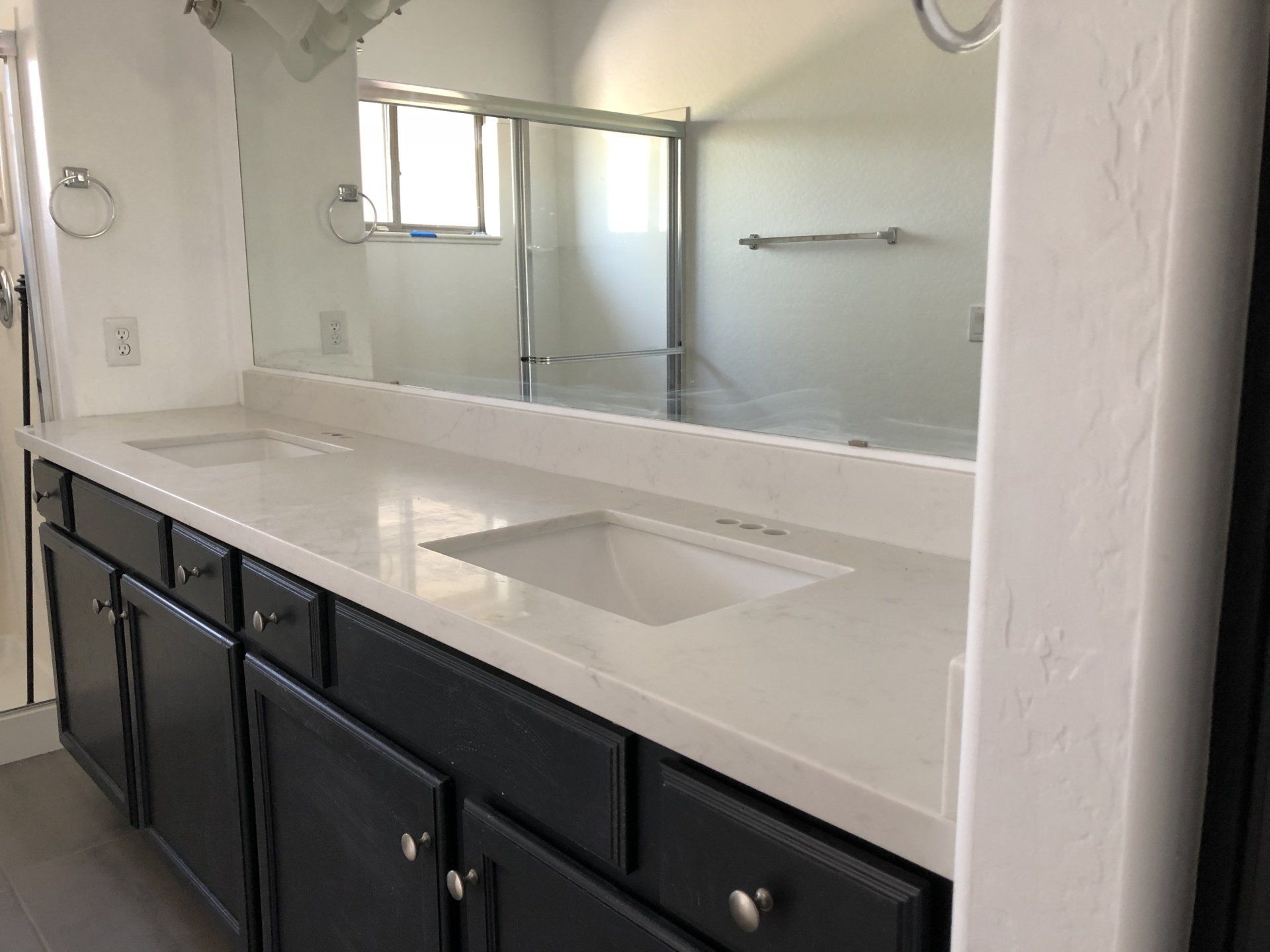 A bathroom with two sinks and a large mirror