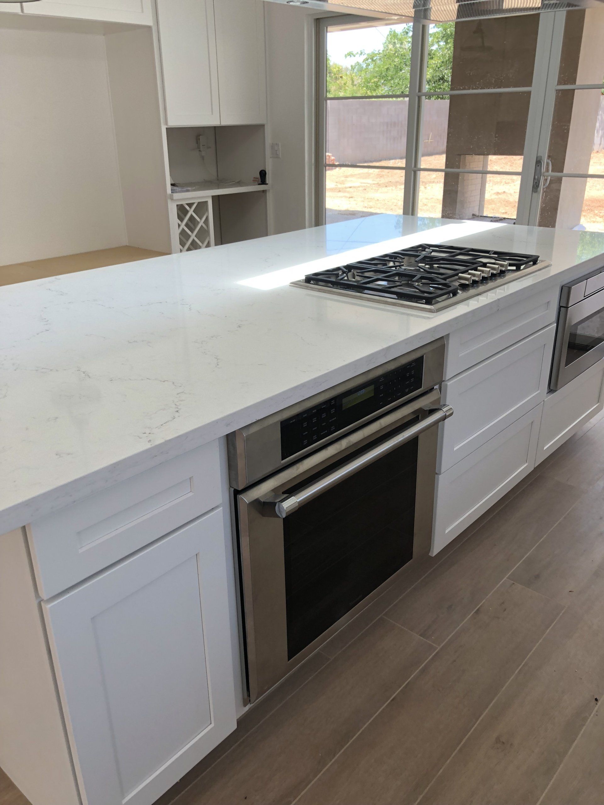 A kitchen with white cabinets and a stove top oven