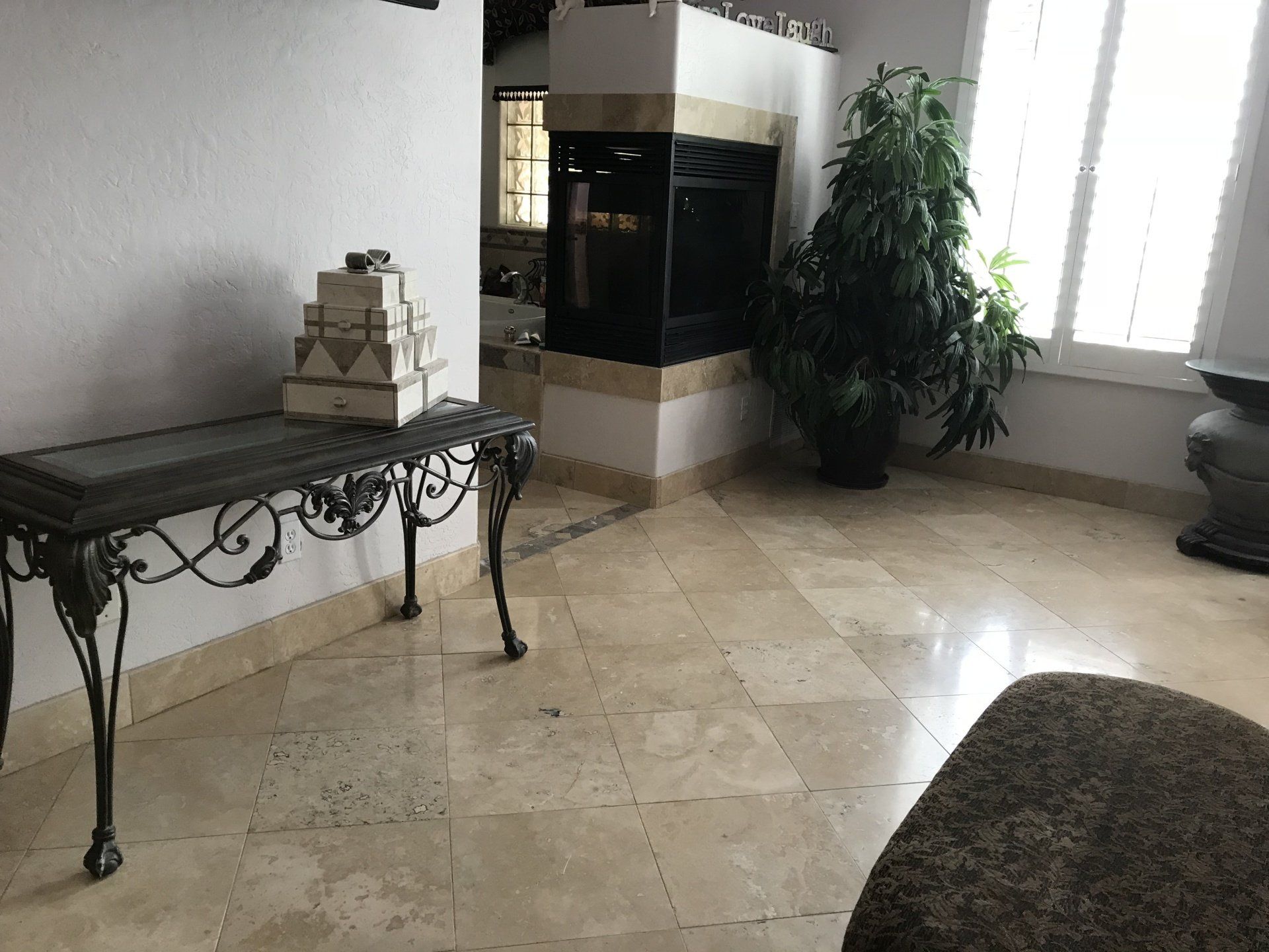 A living room with a table and a fireplace