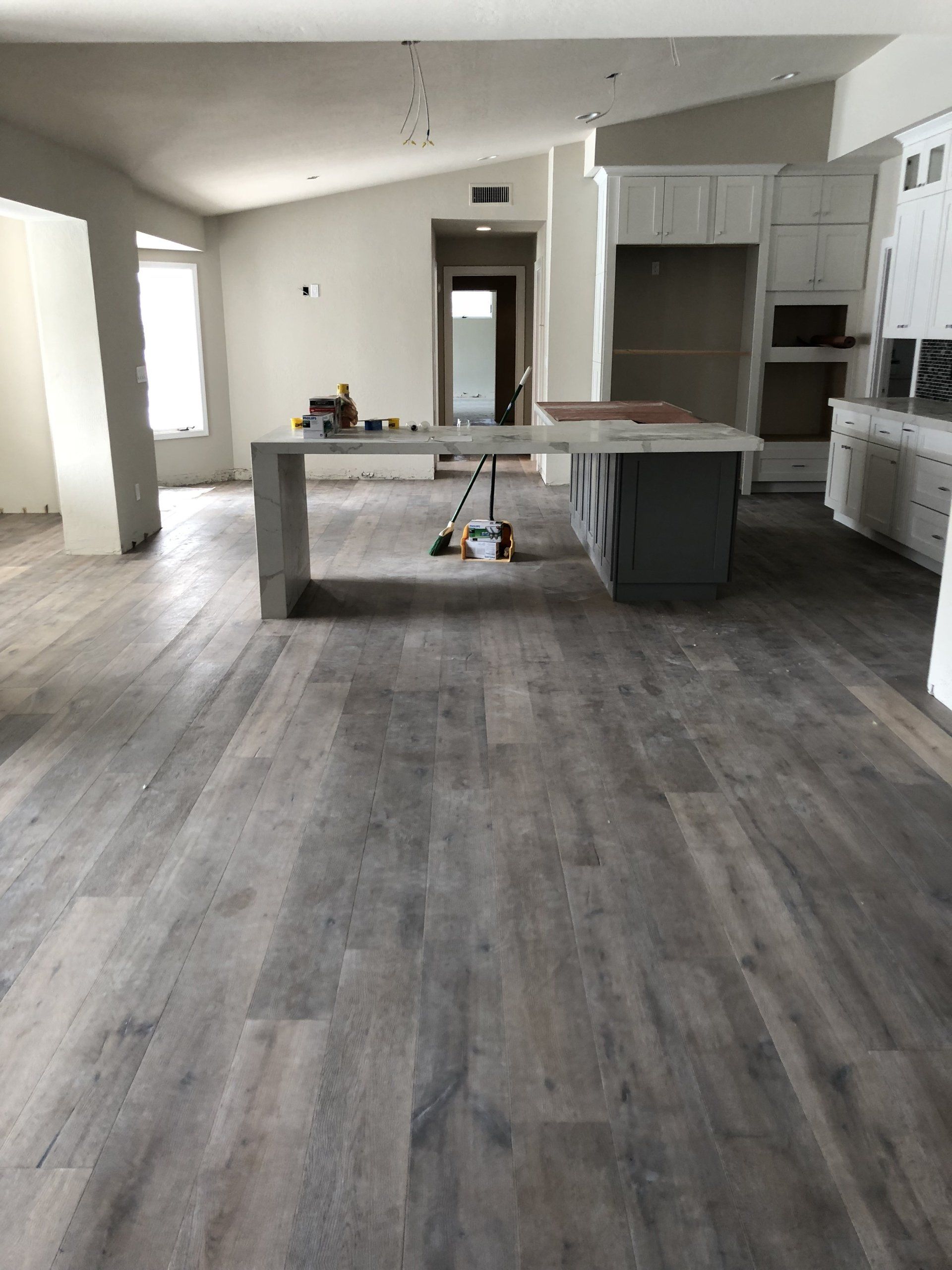 A kitchen with hardwood floors and white cabinets