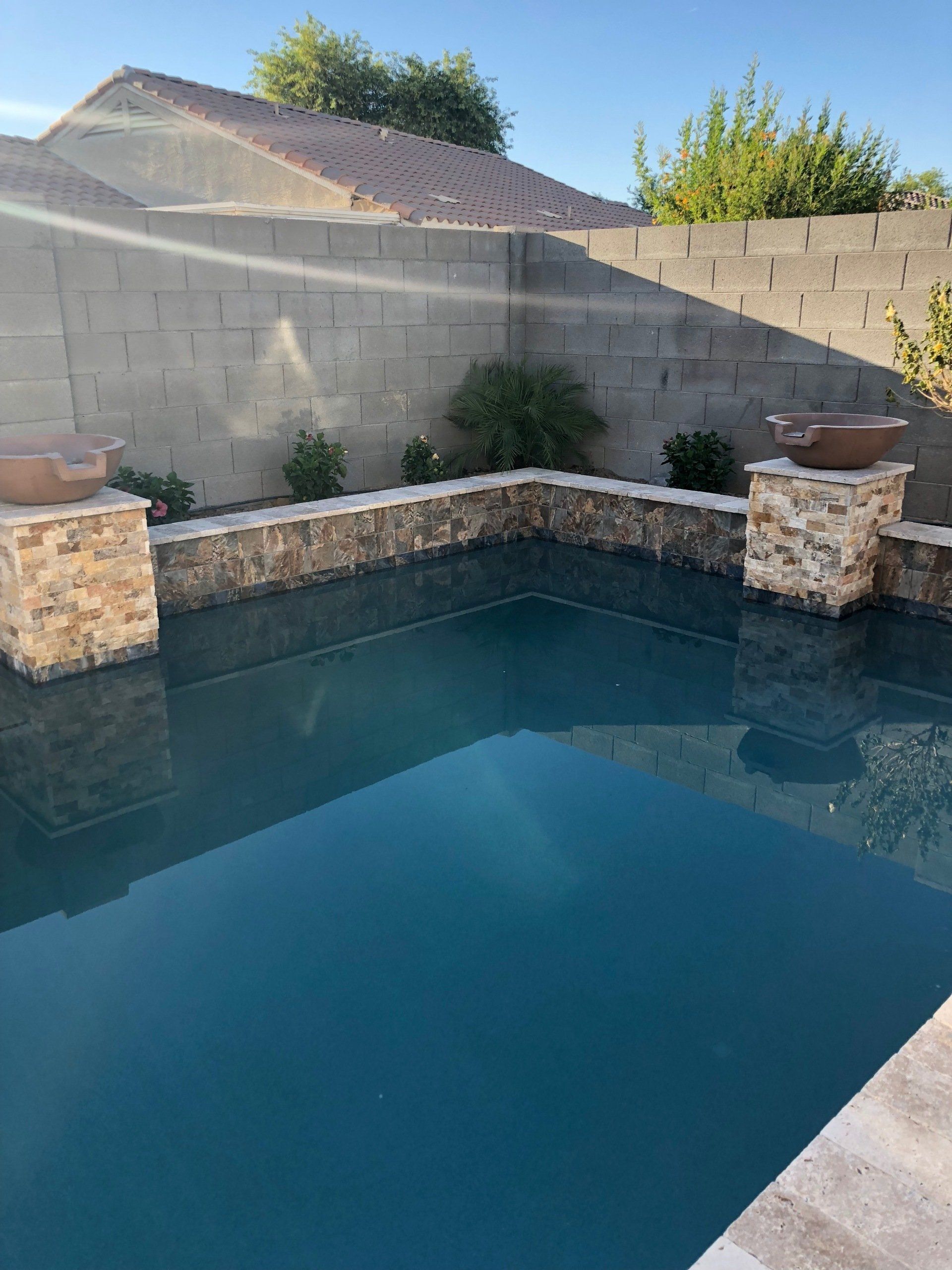 A large swimming pool with a brick wall in the background.