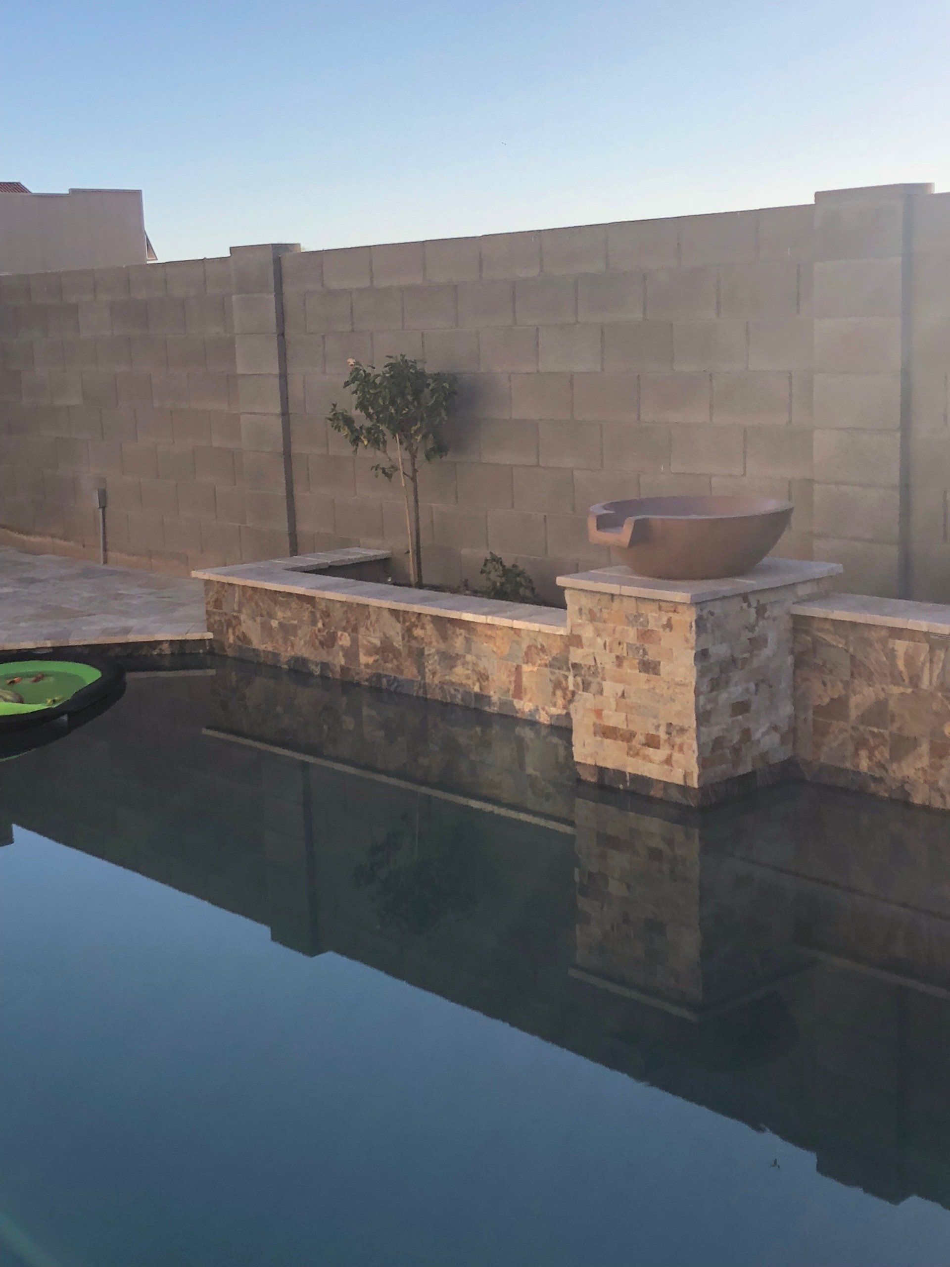 A swimming pool with a brick wall behind it