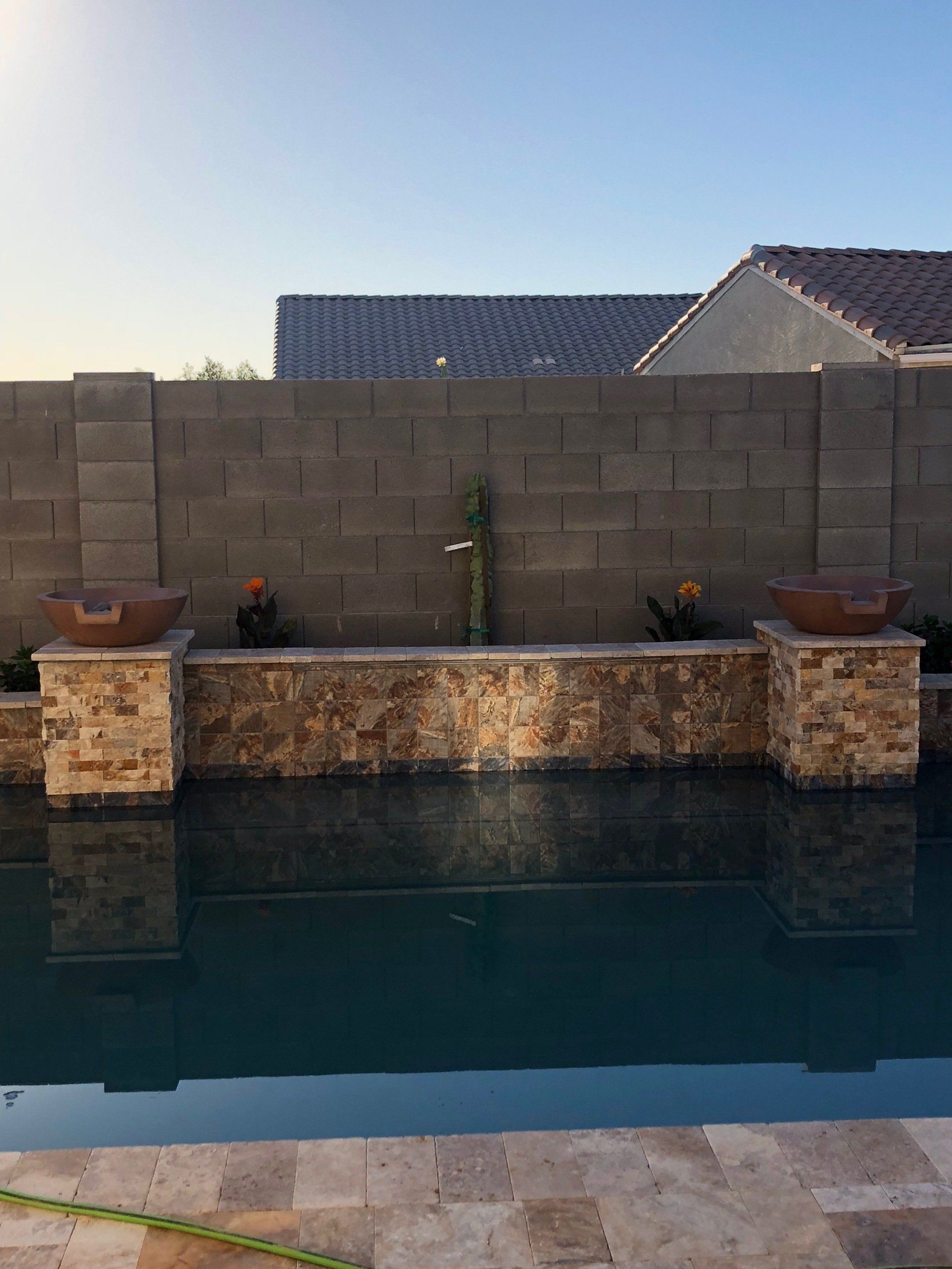 A swimming pool with a brick wall behind it