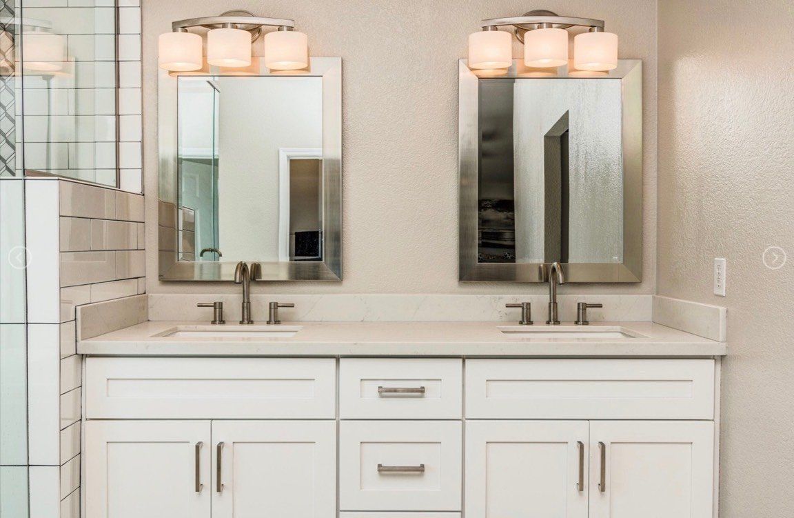 A bathroom with two sinks and two mirrors.