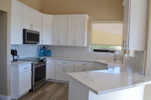 A kitchen with white cabinets and stainless steel appliances.