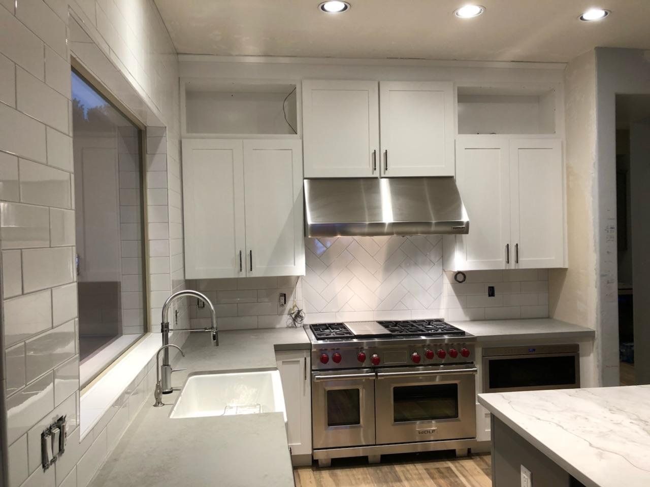 A kitchen with white cabinets and stainless steel appliances.