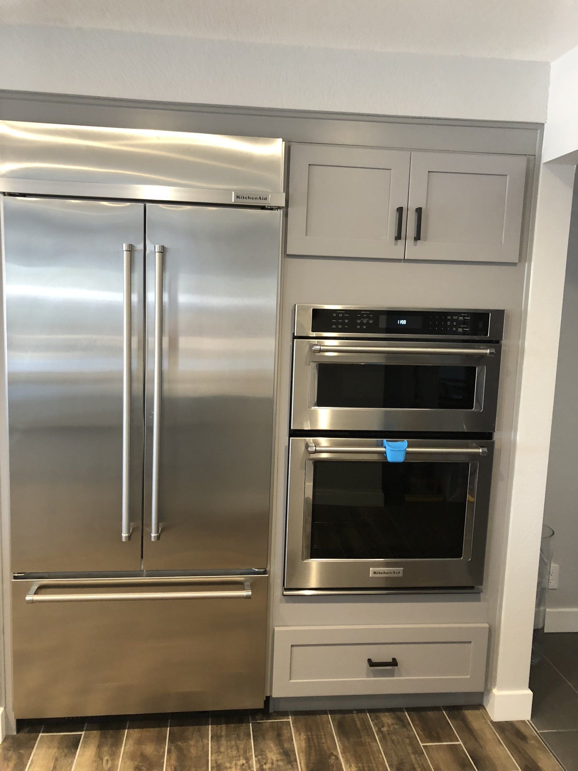 A stainless steel refrigerator and oven in a kitchen