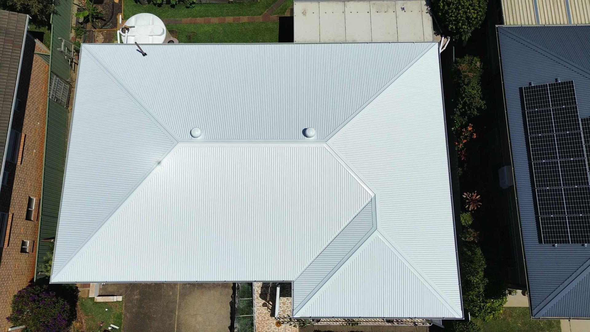 An Aerial View of a House With a Roof in a Grassy Field — Tim Leach Metal Roofing in Wauchope, NSW