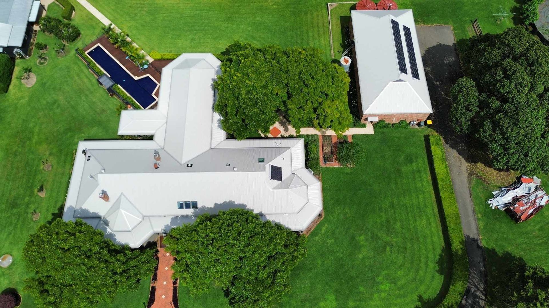 Aerial View of a Large White House With a Long Driveway and Green Lawn — Tim Leach Metal Roofing in Wauchope, NSW
