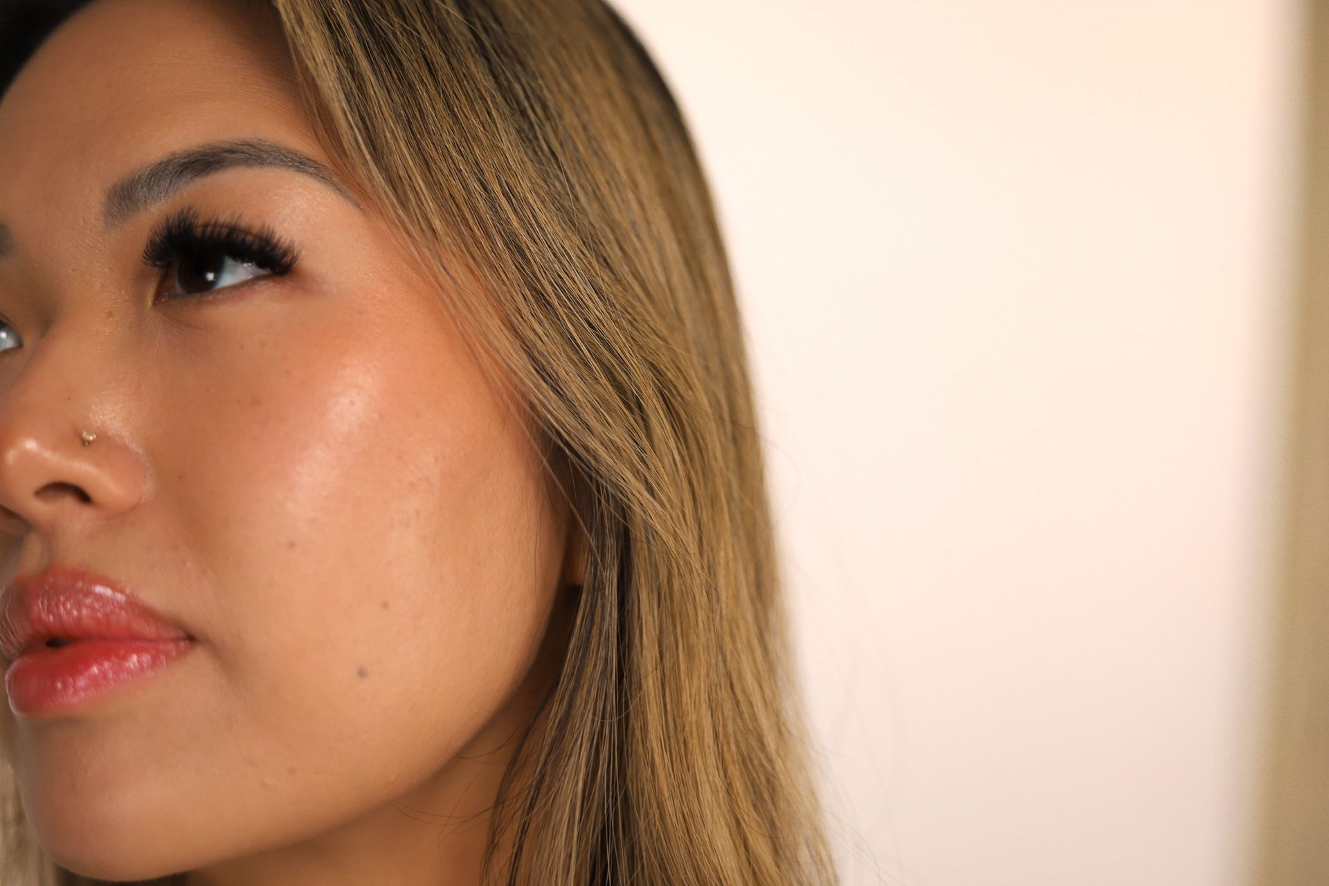 Close-up of a person with closed eyes, dewy skin, and neutral expression.