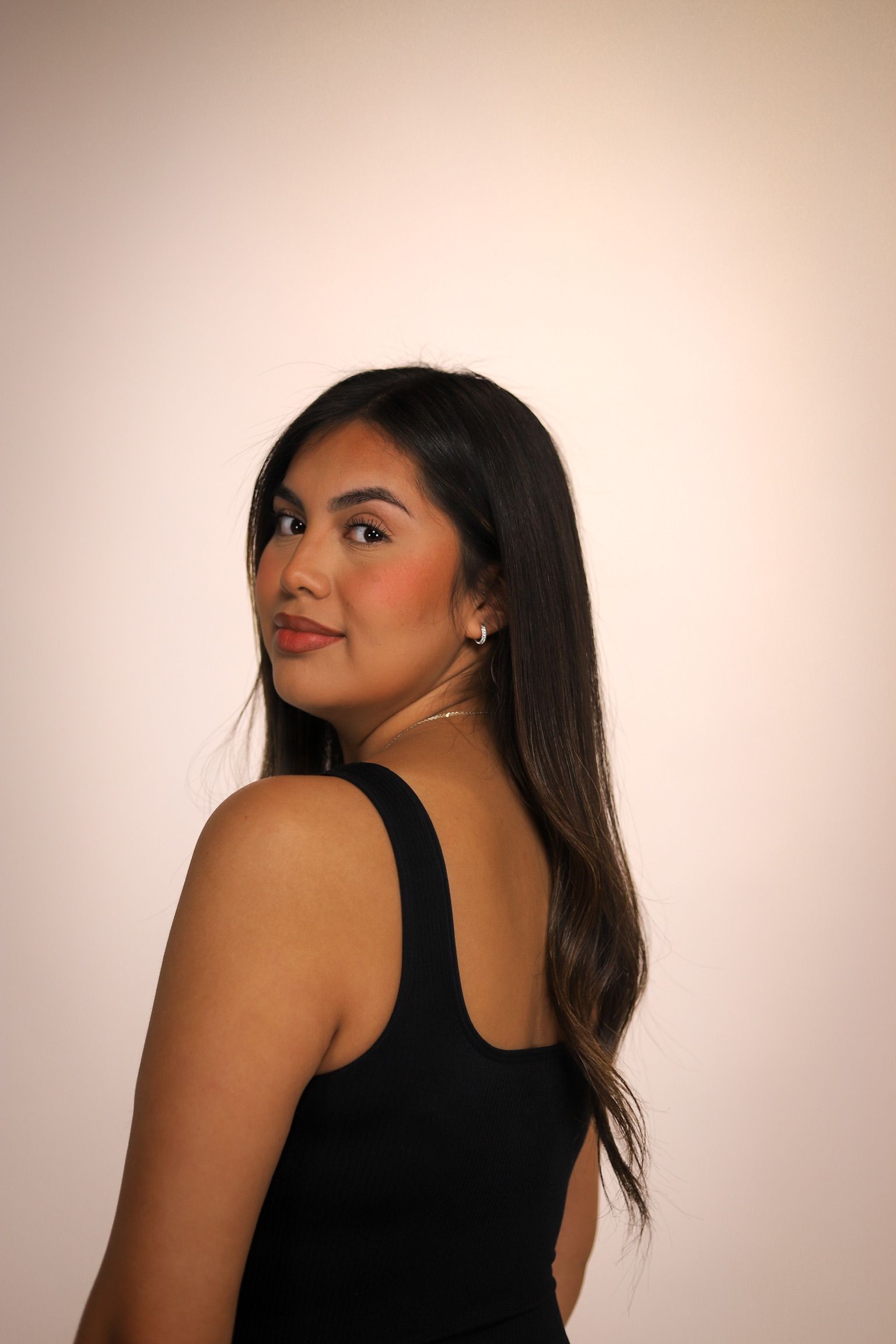 Person's face being waxed. Gloved hands holding a strip on the upper lip. Eyes closed.