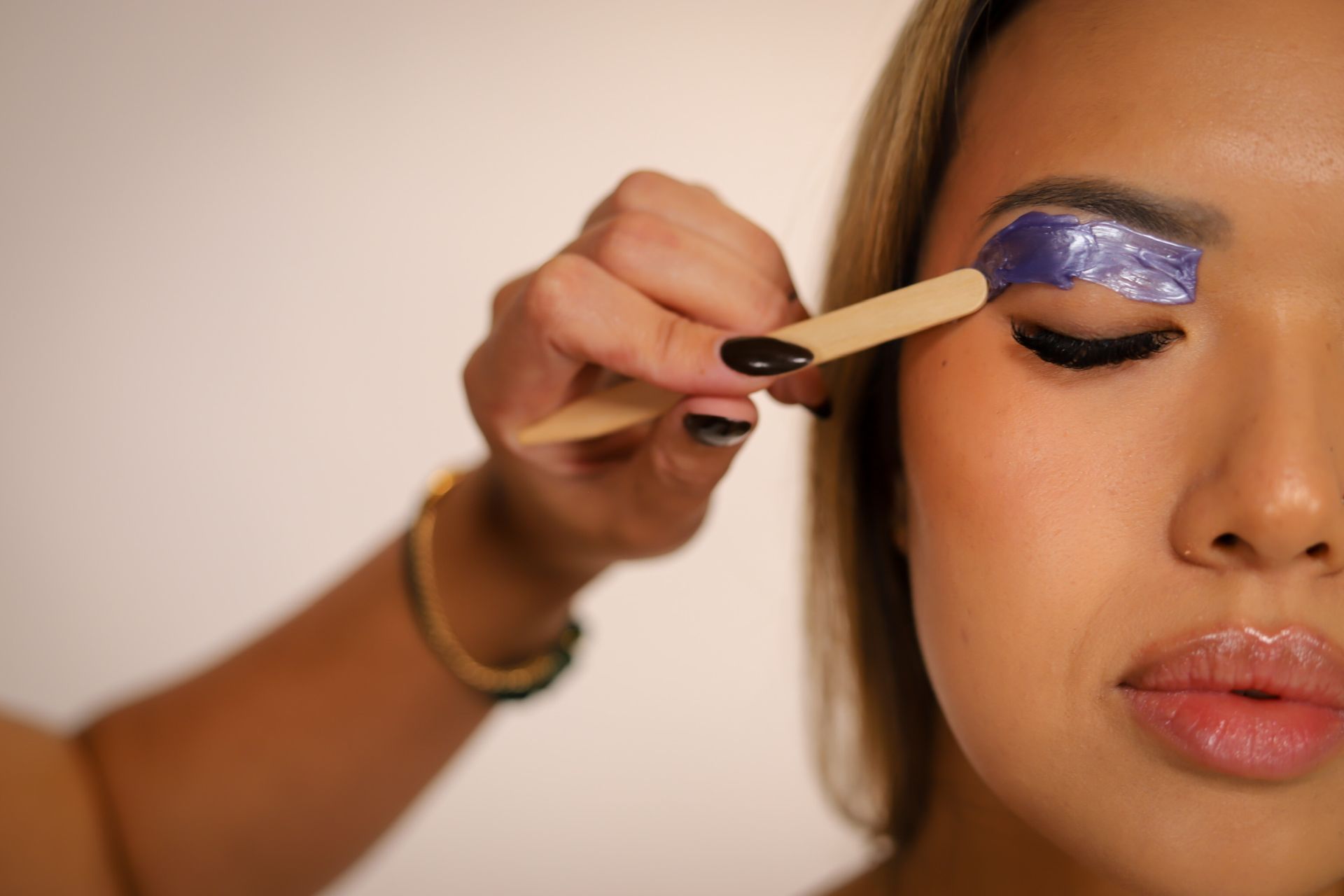 Woman applying false eyelashes.