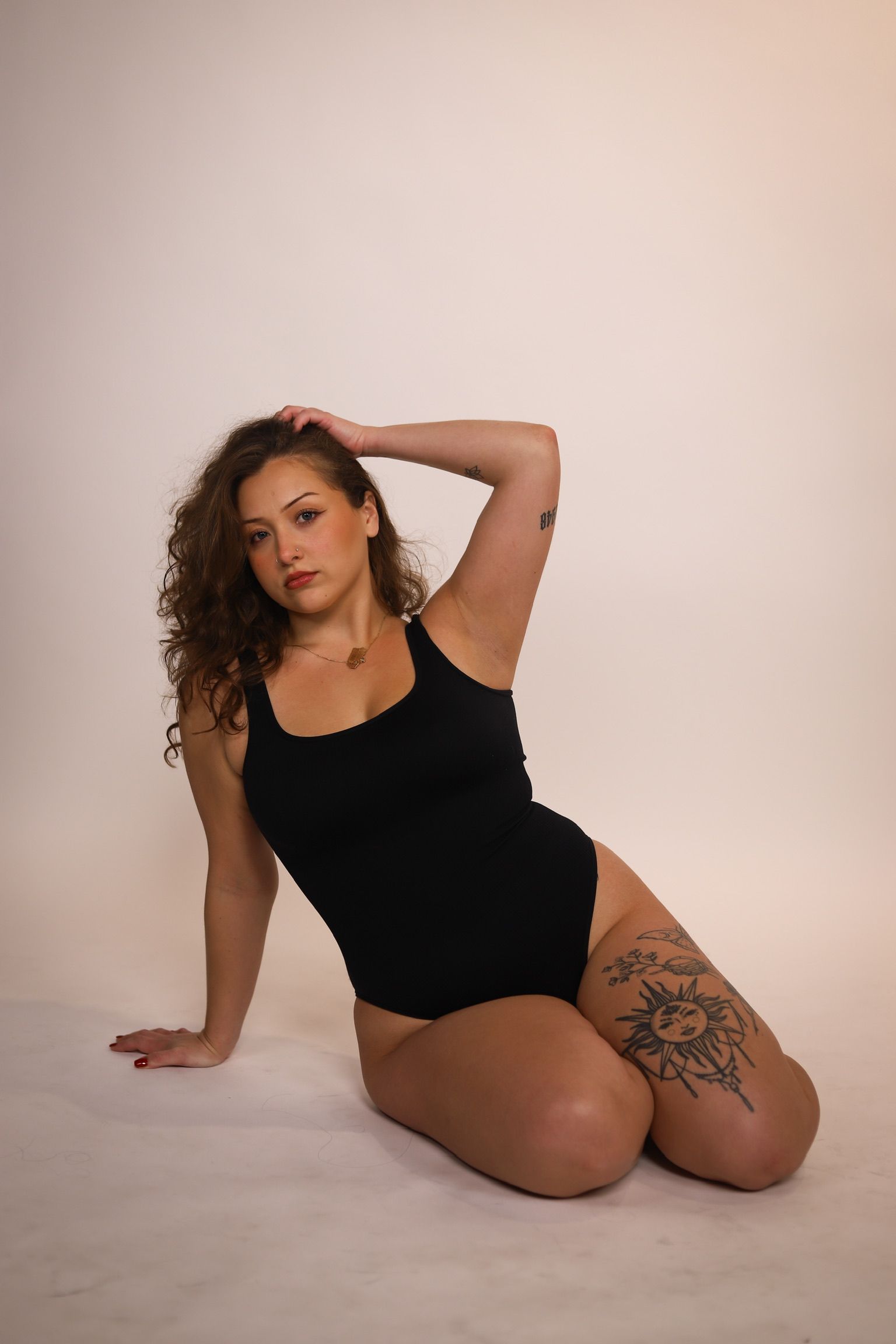 Torso of a person holding a pink flower over their pubic area, against a white background.