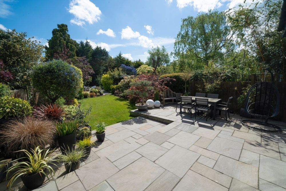 A patio with a table and chairs in a garden