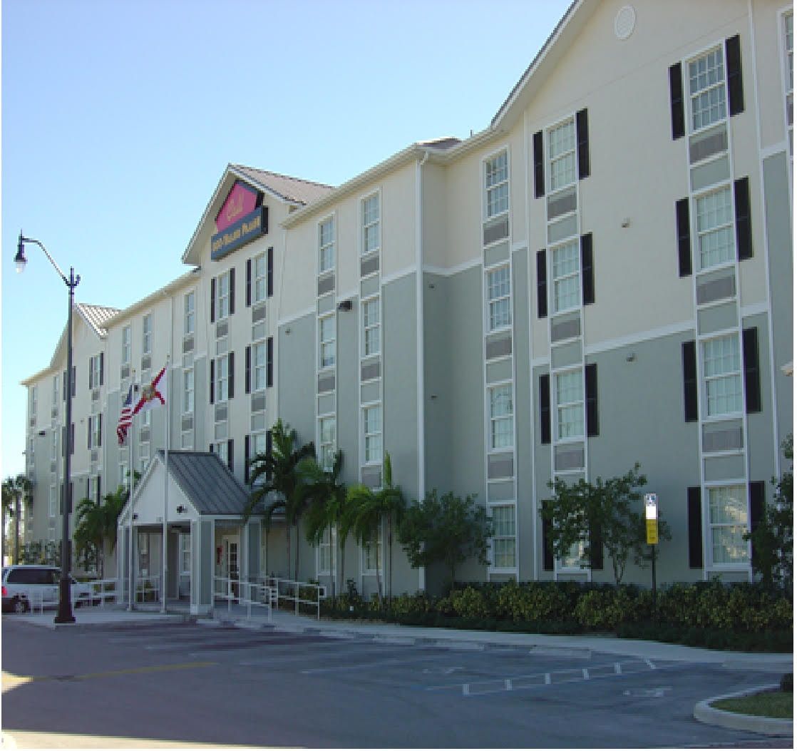 Security fence with barbed wire and a tall communications tower silhouetted against a twilight sky.