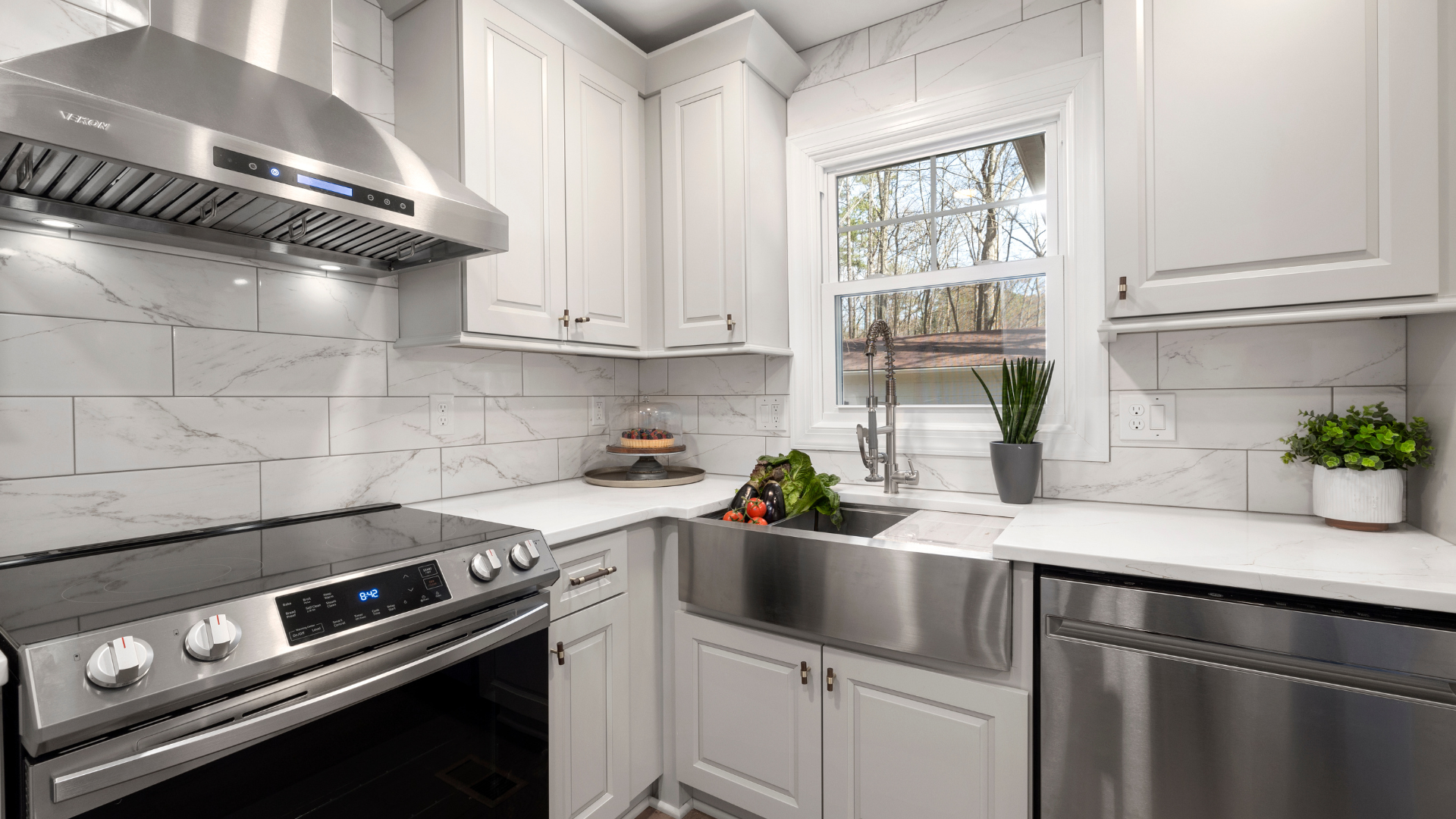 A kitchen with stainless steel appliances and white cabinets.
