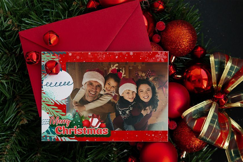 a Christmas card with a picture of a family decorating a Christmas tree
