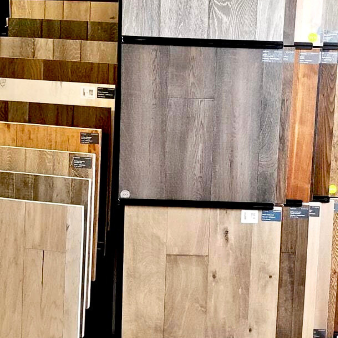 A display of various wood flooring samples in different colors and styles.